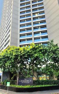 a large building with a sign in front of trees at Gramercy staycaytion in Manila