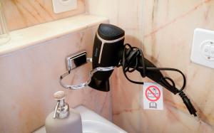 a hair dryer on top of a toilet in a bathroom at Hotel Postigliun Sedrun in Sedrun
