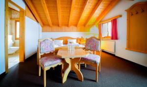a dining room with a table and two chairs at Hotel Postigliun Sedrun in Sedrun
