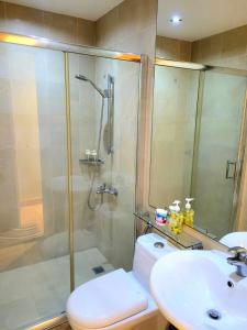 a bathroom with a shower and a toilet and a sink at Gramercy staycaytion in Manila