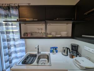 a kitchen with a sink and a counter top at Konnet Apartment in Rhodes Town