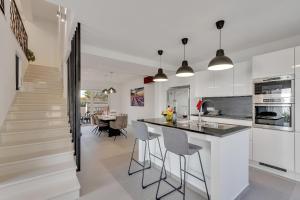 a kitchen with white walls and a island with bar stools at Luxury Apartments Podgora in Podgora