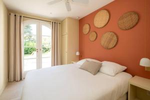 a bedroom with a white bed with orange walls at Sublime maison d'architecte pour famille nombreuse in Les Portes +7 photos