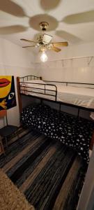 een slaapkamer met een bed en een plafondventilator bij El Silo de Manolo in Romeral