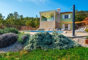 een huis met een zwembad voor een tuin bij Villa Luce in Labin