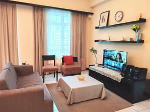 a living room with a couch and a tv at 9 Changkat Jalan Alor Bukit Bintang Pavilion KLCC in Kuala Lumpur