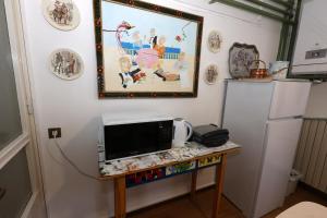 eine Küche mit einem Tisch, einer Mikrowelle und einem Kühlschrank in der Unterkunft La terrazza di Villa Edera in Treviso