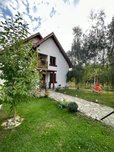 a small white house with a tree in the yard at CONACUL DE SUB MUNTE in Novaci