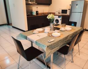 a dining room table with chairs and a kitchen at 9 Changkat Jalan Alor Bukit Bintang Pavilion KLCC in Kuala Lumpur