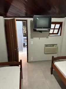 Habitación con TV de pantalla plana en la pared en Hotel Lara's, en Ribeirão Preto