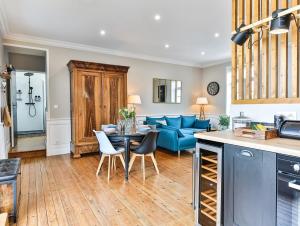 een keuken en een woonkamer met een blauwe bank bij Chaleureux logement-centre ville-proche gare-plage in Les Sables-dʼOlonne