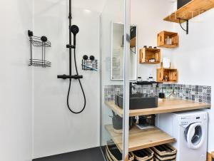 een badkamer met een wastafel en een wasmachine bij Chaleureux logement-centre ville-proche gare-plage in Les Sables-dʼOlonne