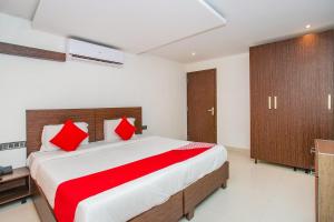 a bedroom with a large bed with red pillows at OYO Corner Golf View Near Embassy Golf Link Business Park in Bangalore