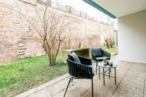 eine Terrasse mit 2 Stühlen und einem Tisch in der Unterkunft BellaBene modernes Studio Apartment in toller Lage mit Terrasse, Parkplatz, SmartTV in Pforzheim