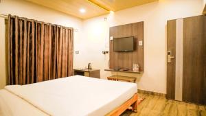 een hotelkamer met een bed en een televisie bij Ansh Resort, Dandeli in Dandeli