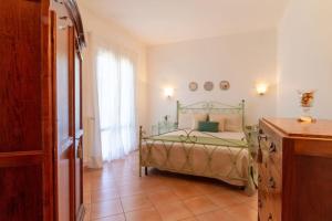 a bedroom with a green bed in a room at Su Trigu, ground floor in Bari Sardo