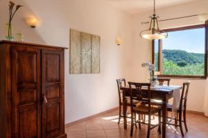 a dining room with a table and chairs and a window at Su Trigu, ground floor in Bari Sardo