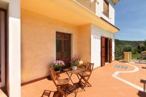 a patio of a house with a table and chairs at Su Trigu, ground floor in Bari Sardo