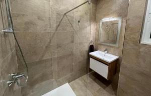 uma casa de banho com um chuveiro, um lavatório e um espelho. em St Julians New 3 Bedroom Luxury Apartment em St. Julian's