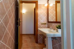 a bathroom with a sink and a toilet and a mirror at Su Trigu, ground floor in Bari Sardo