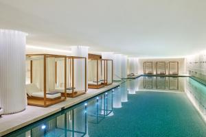 a large swimming pool with blue water in a building at Bulgari Hotel London in London