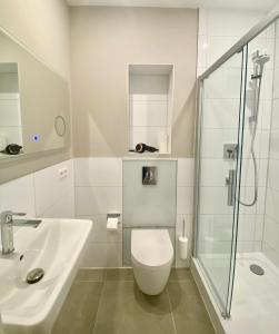 La salle de bains est pourvue de toilettes, d'un lavabo et d'une douche. dans l'établissement Bismarcks Berlin, à Berlin