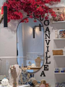 uno specchio in un negozio con fiori rossi sul muro di Camares ad Alopronia
