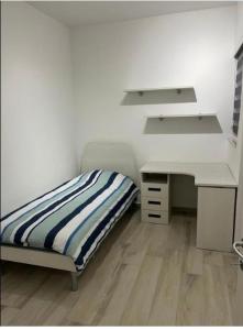 um pequeno quarto com uma cama e uma secretária em St Julians New 3 Bedroom Luxury Apartment em St. Julian's