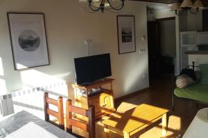 a living room with a flat screen tv and a table at Ibones azules in Sallent de Gállego
