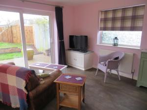 a living room with a couch and a tv at Rowan Berry in Hunstanton