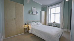 a bedroom with a bed and a window at Burlington Mansions - Stunning Coastal Apartment in Bournemouth