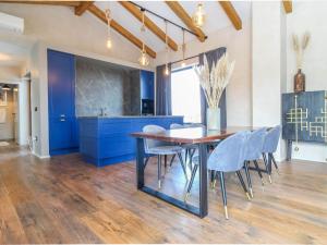 eine Küche mit blauen Schränken sowie einem Holztisch und Stühlen in der Unterkunft Beautiful Villa Una Sofia with pool in Tinjan in Vela Traba