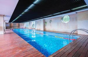 a large swimming pool with blue water in a building at UrCove by Hyatt Shanghai Pudong East in Shanghai