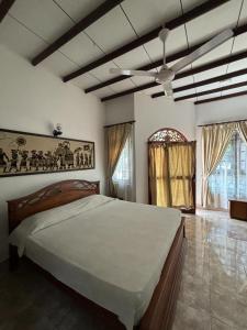 1 dormitorio con 1 cama grande y ventilador de techo en Village Inn Resort en Negombo