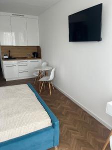 a bedroom with a bed and a tv on a wall at Apartament Planeta 202 - tylko 100 m do plaży, odnowiony w 2024 in Mielno