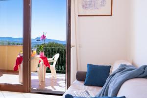 een woonkamer met een bank en een tafel en een balkon bij Le corti del turchese in Badesi