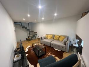 uma sala de estar com um sofá e uma televisão em alojamiento Tinajas em La Coruña