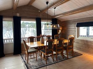 a dining room with a wooden table and chairs at Large and cosy mountain cabin in Sykkylven