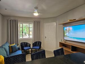 a living room with a large flat screen tv at Flat na Riviera de São Lourenço com serviço de hotelaria in Riviera de São Lourenço