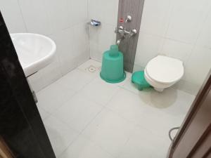 a bathroom with a toilet and a sink at Hotel Horizon Vapi in Vapi