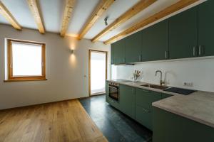 an empty kitchen with green cabinets and a window at Casa Corradini by Go New Location in Carano