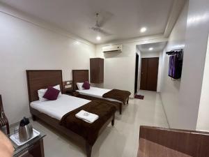 a hotel room with two beds in a room at Hotel Horizon Vapi in Vapi