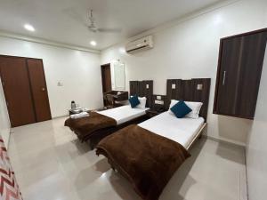 een kamer met drie bedden in een kamer bij Hotel Horizon Vapi in Vapi