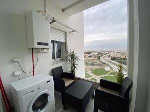 a laundry room with a washing machine and a window at chez vicky in Tunis