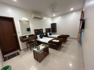 a room with a bed and a couch and a table at Hotel Horizon Vapi in Vapi