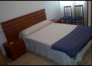 um quarto com uma cama grande e 2 cadeiras em APARTAMENTO PUERTO-ELMAR em Benicarló
