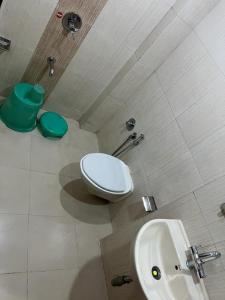 a bathroom with a toilet and a sink at Hotel Horizon Vapi in Vapi