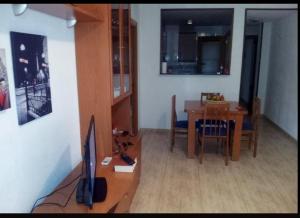 uma sala de estar com uma mesa de jantar e uma televisão em APARTAMENTO PUERTO-ELMAR em Benicarló