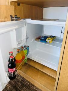 um frigorífico aberto cheio de bebidas e alimentos em KHAN ORDASY em Zhezqazghan