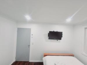 1 dormitorio con 1 cama y TV en la pared en Kaban Power 39, en Bidwill